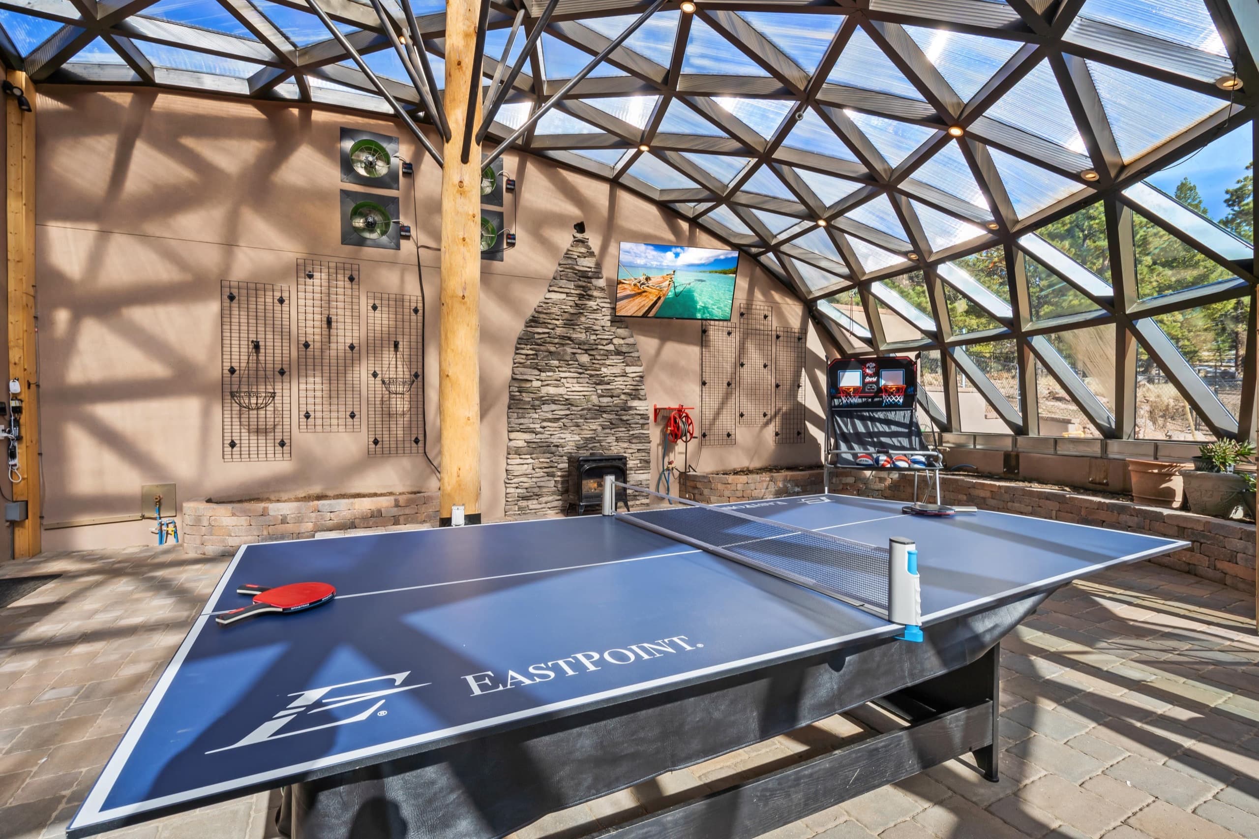 Inside the geodesic dome: ping pong, a basketball arcade game, and a glass roof open to the Colorado sky